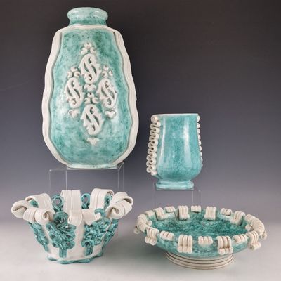 three vases and a bowl on display on a table