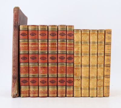 several old books stacked on top of each other on a white surface