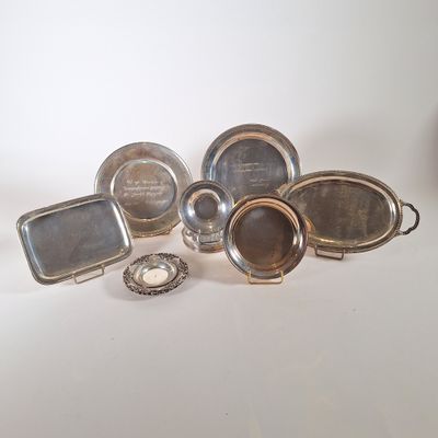 assiettes et plateaux plaqués argent sur un fond blanc