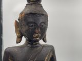 statue of a seated person with a pointed hat on his head