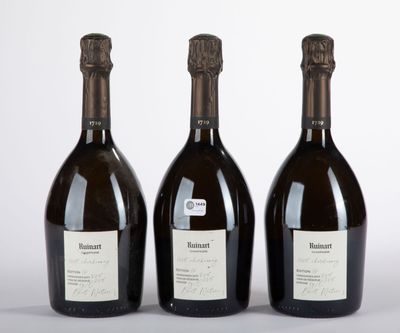 trois bouteilles de vin posées l'une à côté de l'autre sur une table