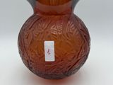 a brown glass vase with a red label on it