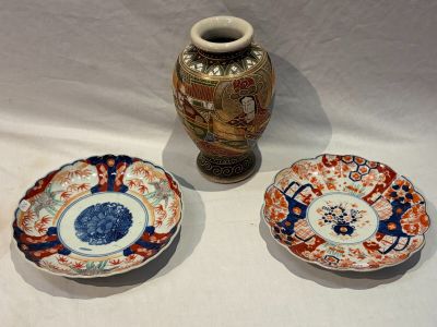 trois assiettes et un vase posés sur une table