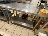 une grande table en acier inoxydable au milieu d'une cuisine