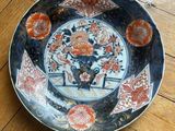 a plate with a clock on it sitting on a wooden floor