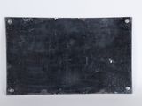 an old black metal plate with rivets on a white background