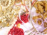 a white plate with gold and red jewelry on it