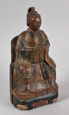 an old wooden statue of a man sitting on a chair