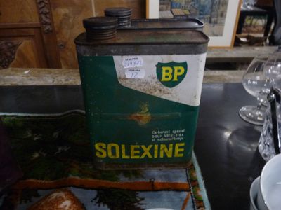 une canette de Solexine posée sur une table à côté d'un verre d'eau