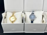 deux montres dans un coffret blanc : une montre dorée et une montre bleue
