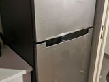 a refrigerator in the corner of a kitchen next to a sink