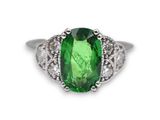 un gros plan sur une bague sertie d'une tourmaline verte et de diamants