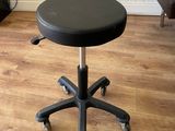 un tabouret noir à roulettes avec une fleur dans un vase
