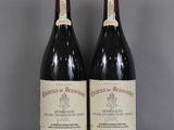 deux bouteilles de vin posées sur une table l'une à côté de l'autre