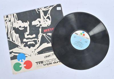 un vieux disque vinyle posé sur une table, à côté d'un CD