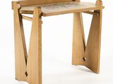 a small wooden table with a tile top on it