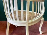 a white chair with a basket on top of it