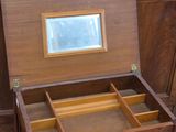 a small wooden table with a mirror on top of it