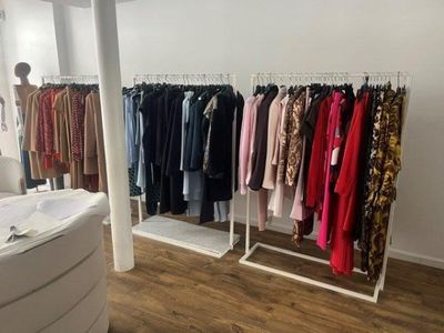 de nombreux vêtements suspendus à un portant dans une pièce