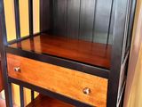 une étagère en bois avec deux tiroirs, dans une pièce