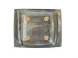 a small square plate with holes in the middle