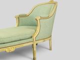 a green and gold chaise lounger with a green upholstered cushion