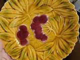 a person holding a yellow plate with cherries on it