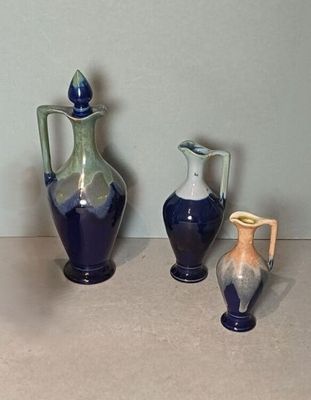 trois vases posés l'un à côté de l'autre sur une table