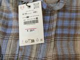 a close up of a blue and brown plaid shirt with a tag on it