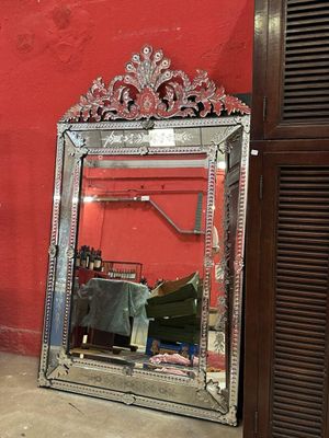 un miroir posé sur le sol devant un mur rouge