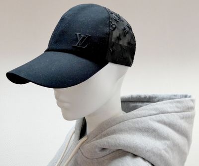 a mannequin head wearing a black hat and a gray hoodie