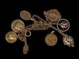 plusieurs types différents de pièces d'or et de breloques suspendues à une chaîne