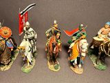 seven figurines of men riding horses and holding flags