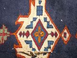 a hand that is holding a piece of fabric with a needle