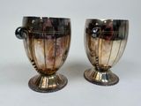 pair of silver vases with handles on a white surface