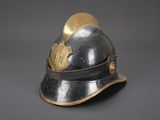 an old helmet with a shield on top of it on a gray surface