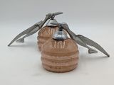 two metal birds that are sitting on top of a glass jar