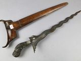 pair of antique wooden and metal daggers on a white surface