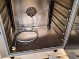 a stainless steel oven with a hose inside of it