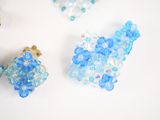 three pieces of blue and white beads on a white surface