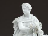 a statue of a woman sitting on a horse holding a flower