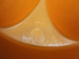 a close up of a plastic container with orange juice in it
