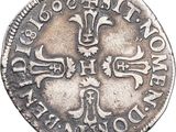 a close up of a silver coin with a cross on it