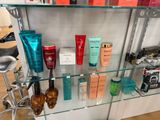 a glass shelf that has many different types of cosmetics on it