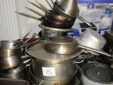 de nombreuses casseroles et poêles posées sur une table