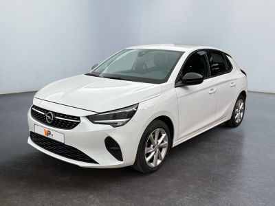L'Opel blanche est garée dans une pièce au sol noir.