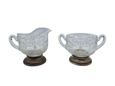 pair of white glass creamer and sugar bowl on wooden stand