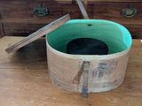 a wooden bucket with a lid on a wooden table