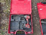 two tools in a red case sitting on the ground