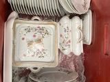 a lot of plates and bowls in a red box